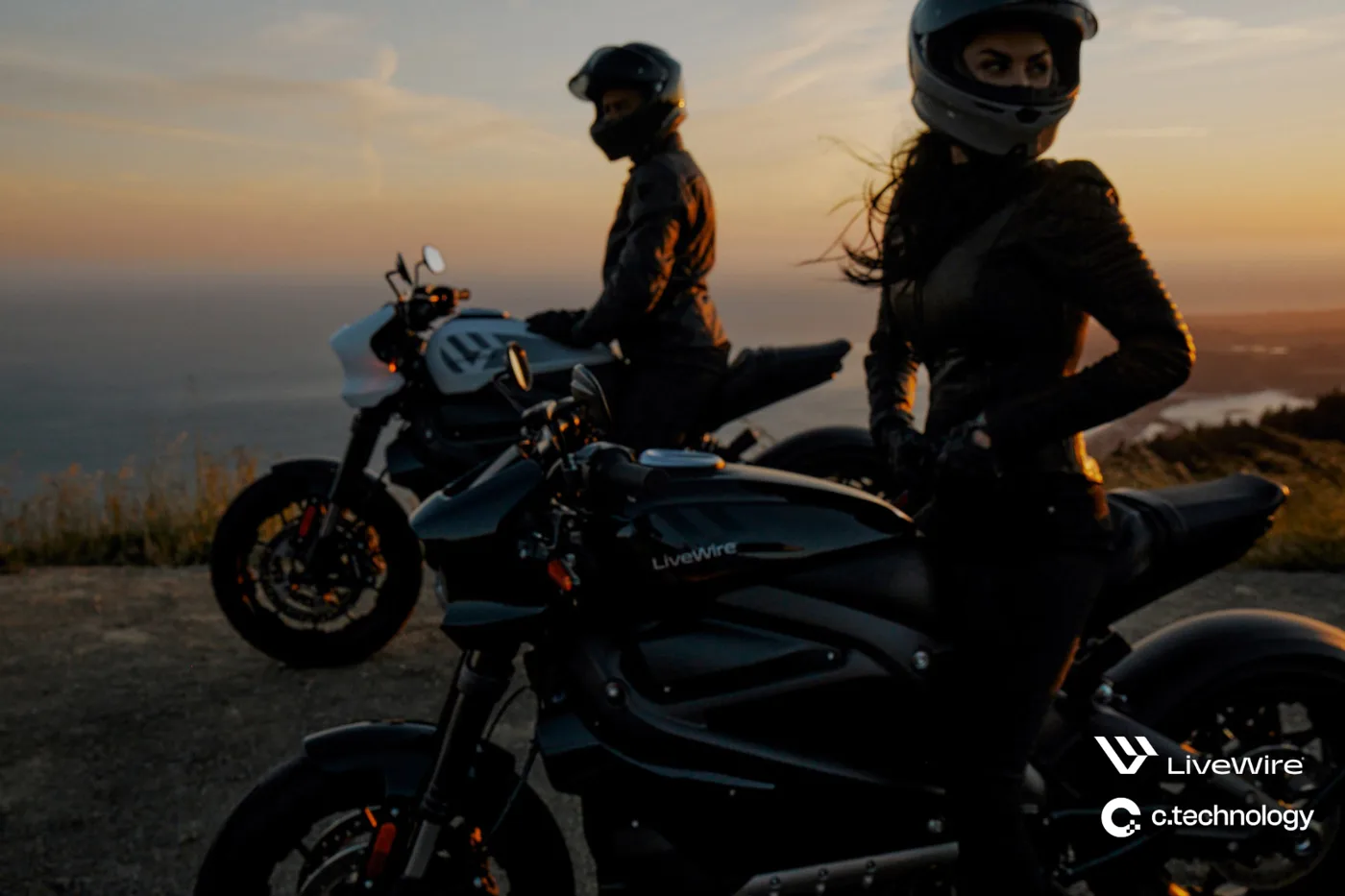 Two riders beside LiveWire electric motorcycles at sunset